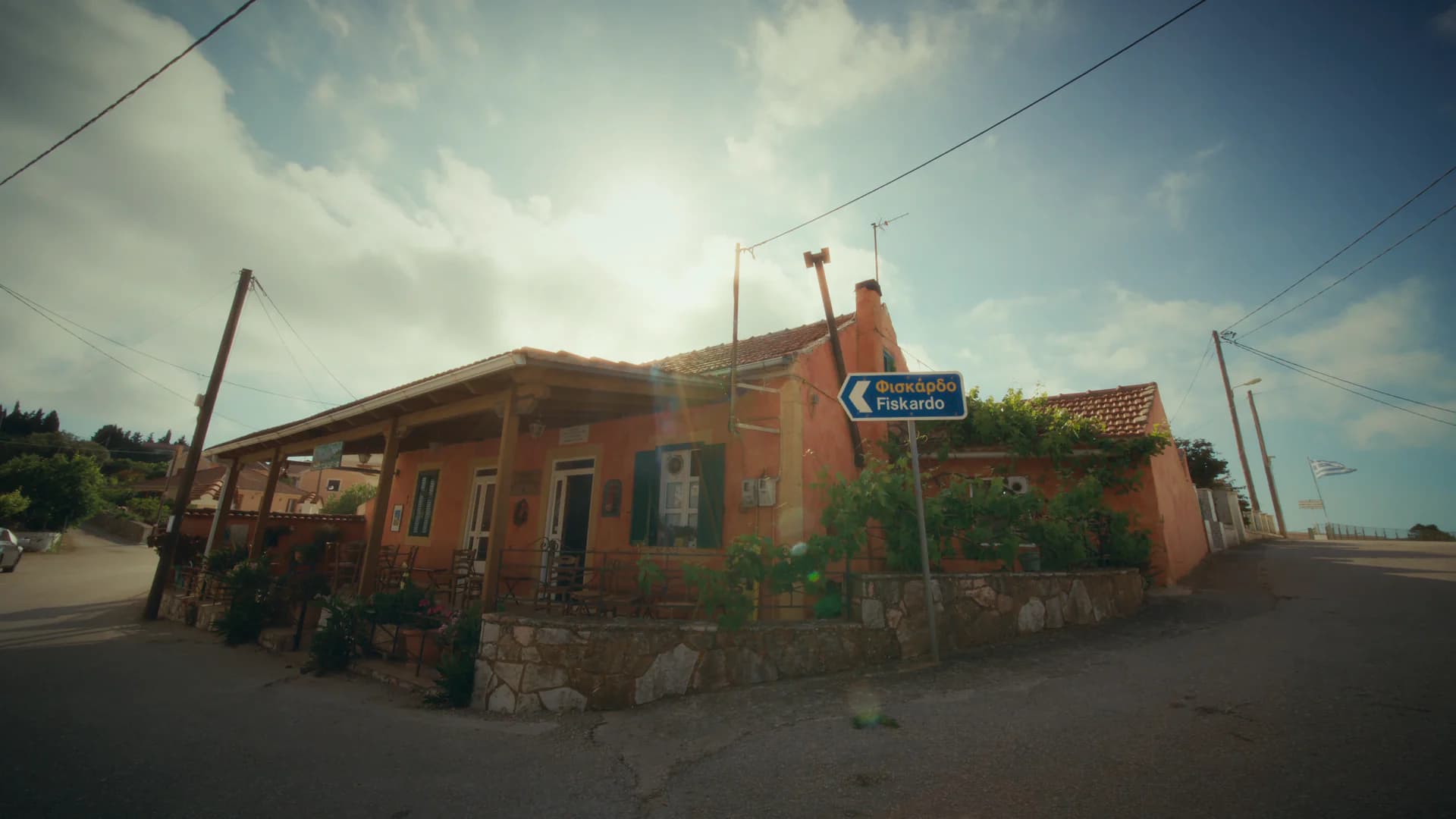 A village crossroads beneath a wide summer sky on a Greek island