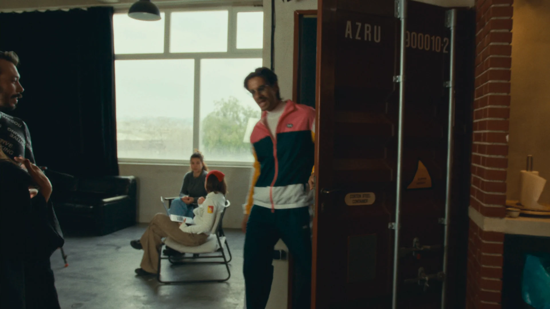 Karavas entering a daylight studio while the crew watches