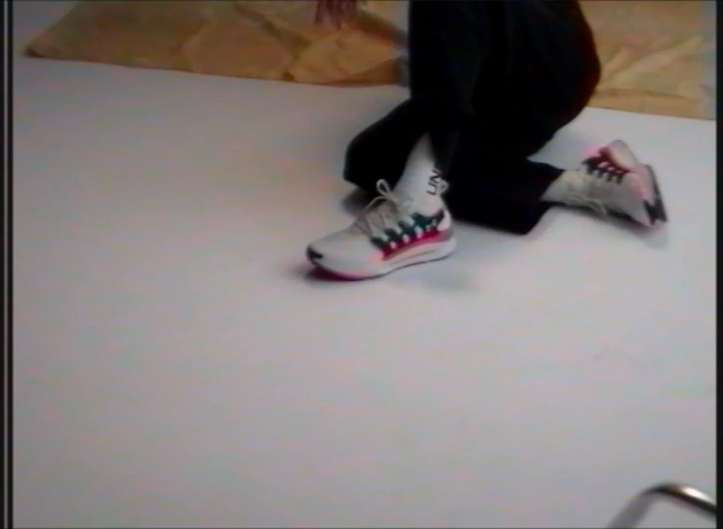 Karavas crouching on the studio floor in the custom Under Armour shoes