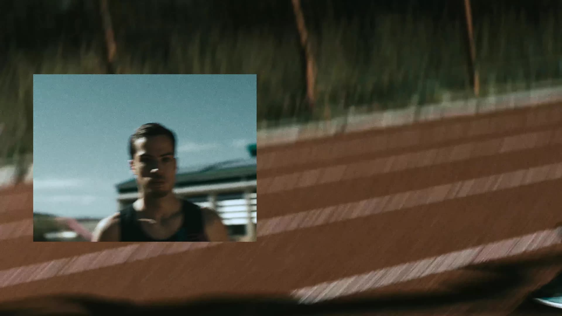 Layered runner portrait cutting across an outdoor track at night