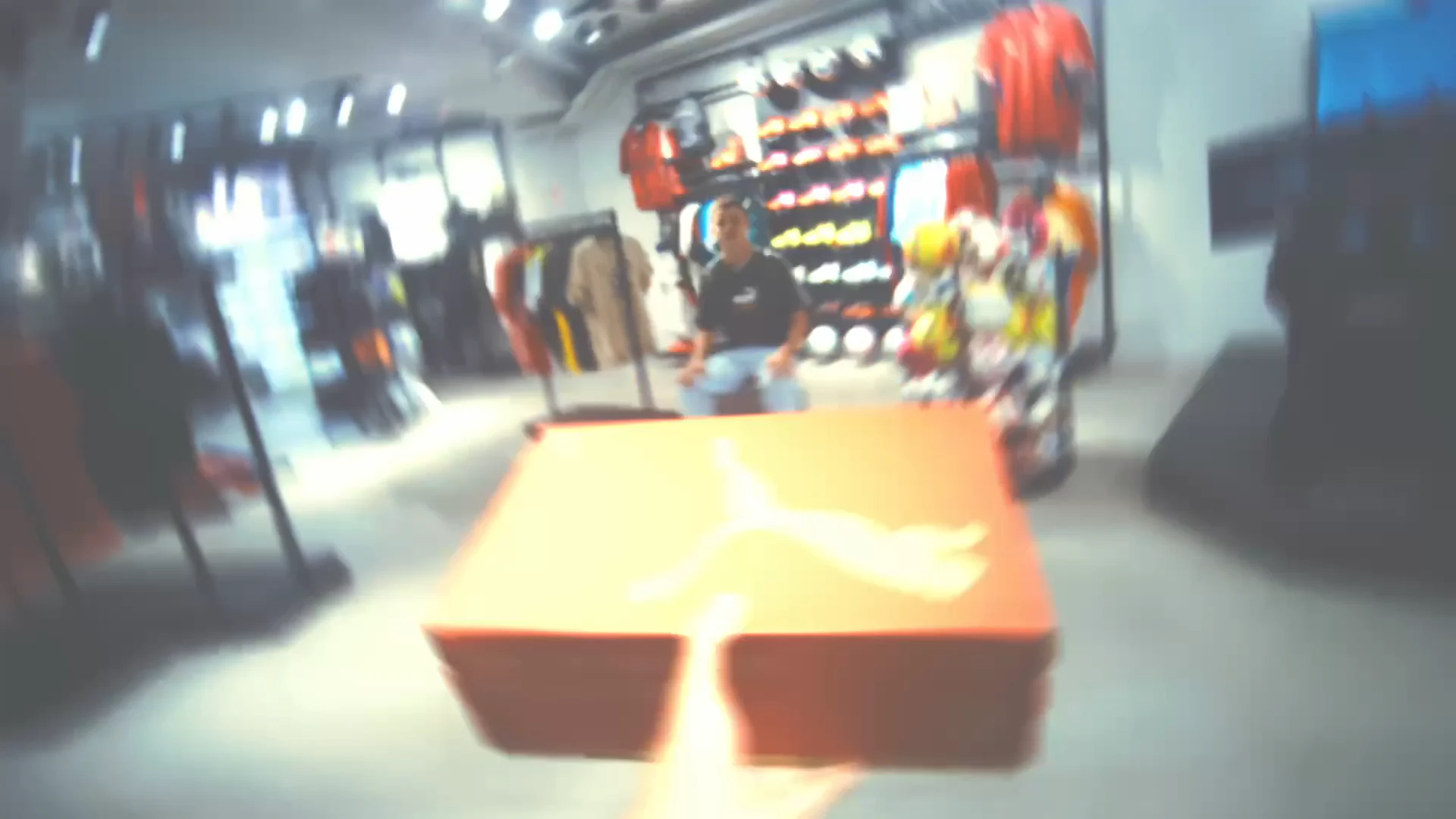 Orange retail display rushing through the centre of a sports store
