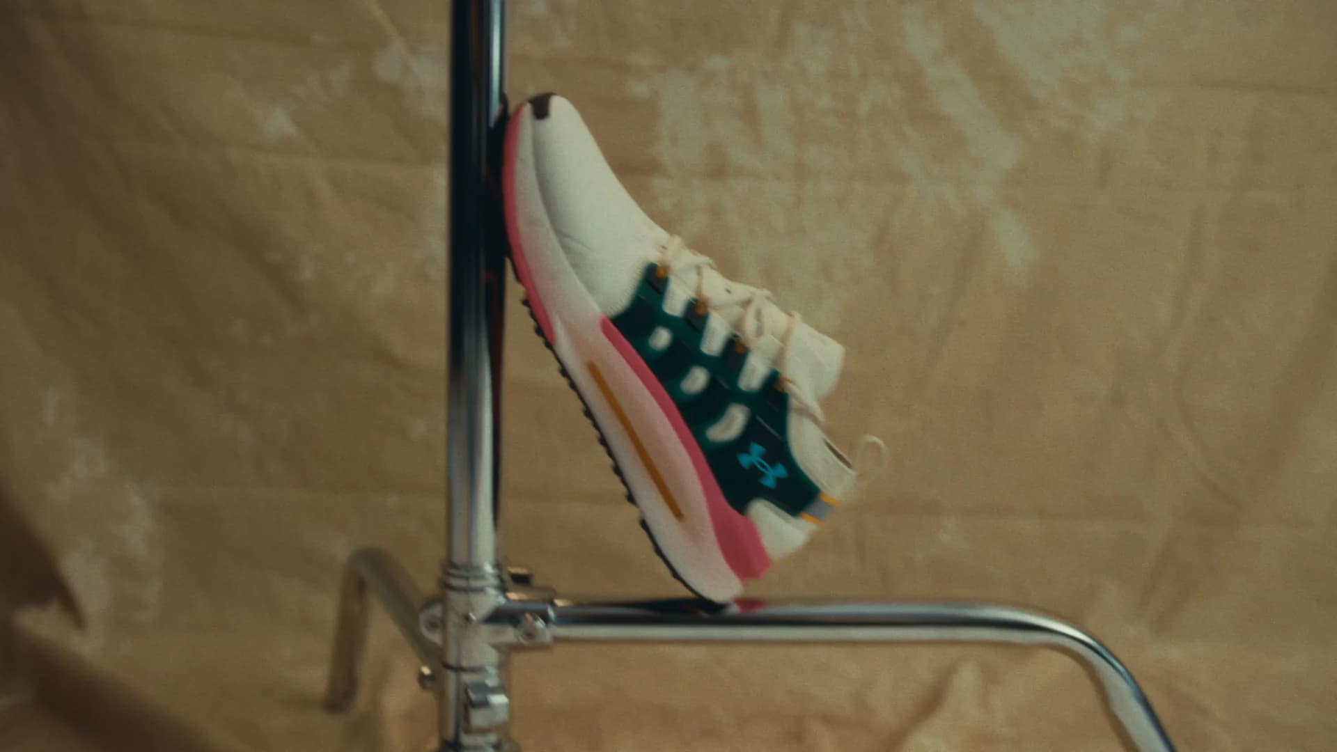 Karavas revealing a custom-finished Under Armour shoe inside a daylight studio