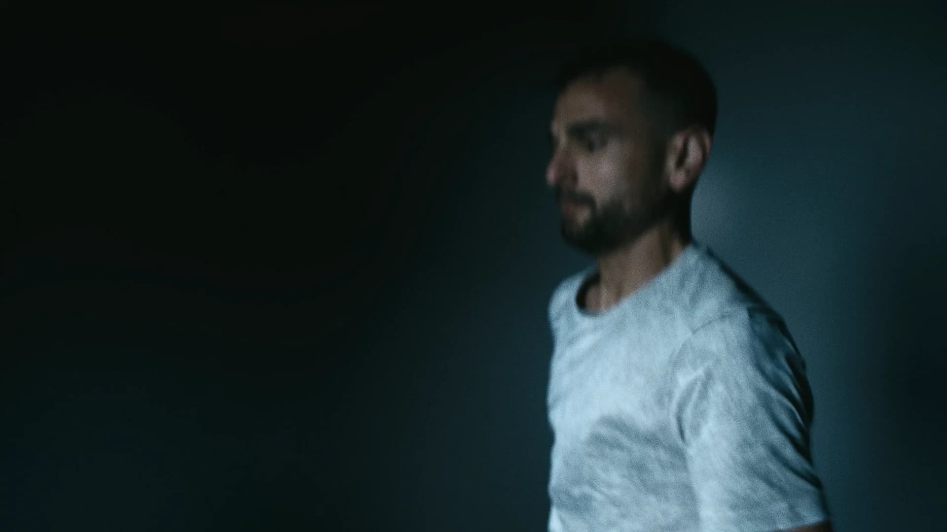 A runner in a white top caught in cold night light