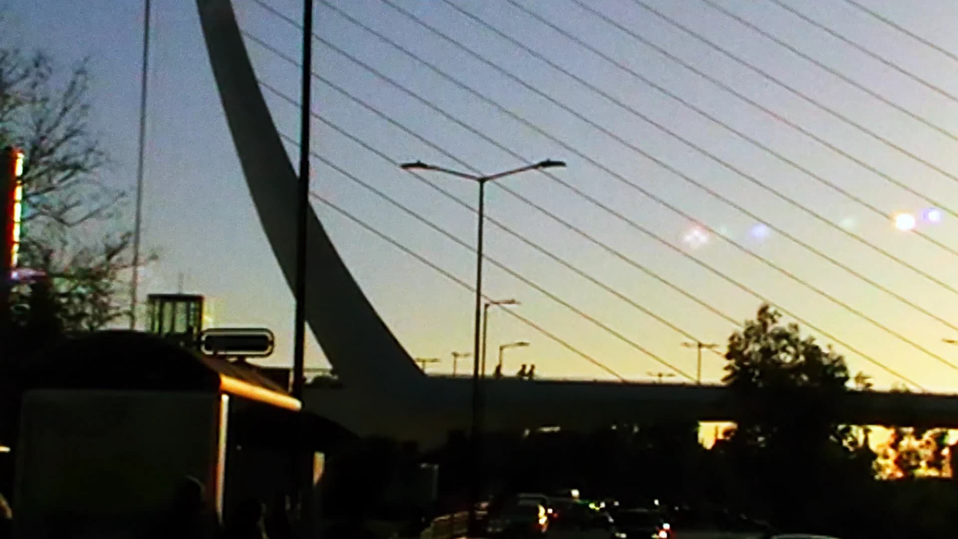 Cable-stayed bridge silhouetted against a low evening sun