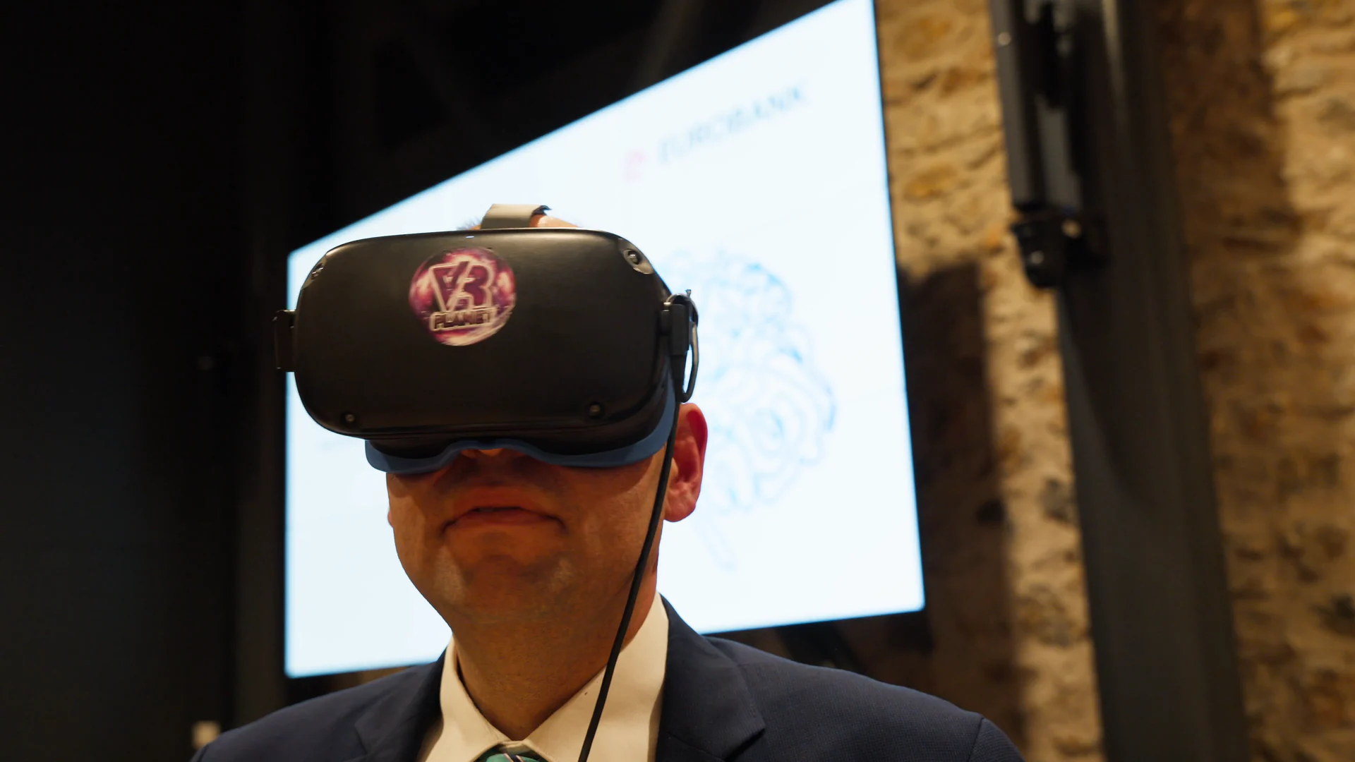Guest wearing a virtual-reality headset in front of the event projection