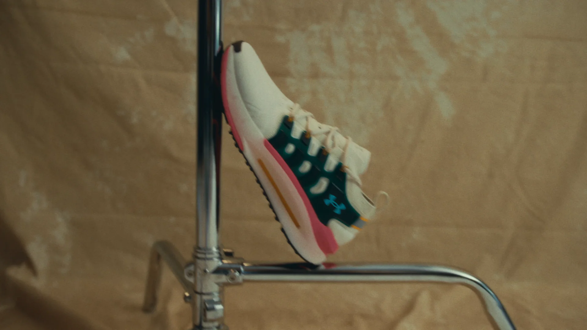 Karavas revealing a custom-finished Under Armour shoe inside a daylight studio